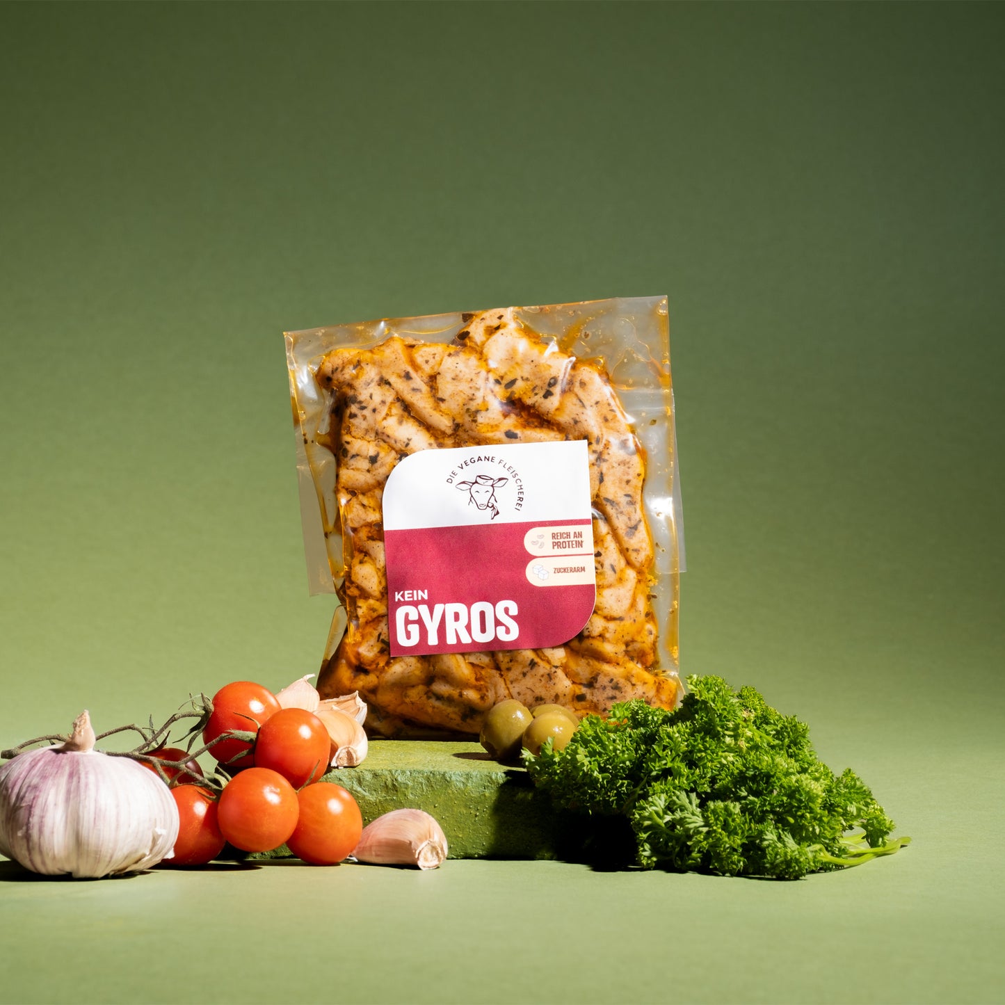 Vegane Gyros-Scheiben, proteinreich & zuckerarm, umgeben von frischen Tomaten, Knoblauch und Petersilie