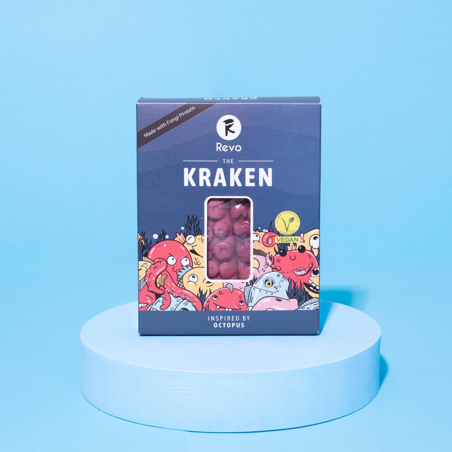 Verpackung des veganen Revo Kraken auf blauem Podest vor blauem Hintergrund.