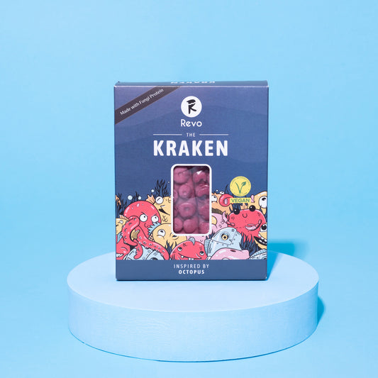 Verpackung des veganen Revo Kraken auf blauem Podest vor blauem Hintergrund.