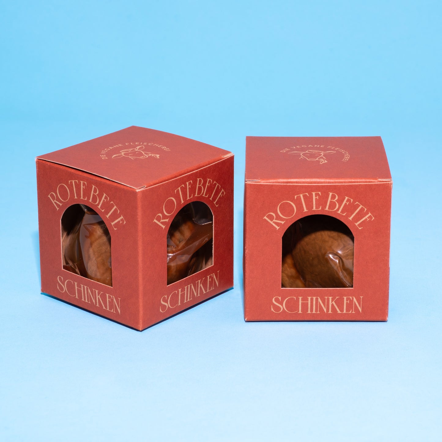 Rote Box mit veganem Rote-Bete-Schinken auf blauen Hintergrund.